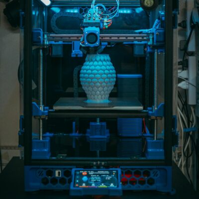 Close-up of a 3D printer in action, crafting a detailed vase in a modern setting.