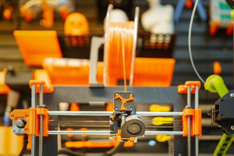 Close-up of an advanced 3D printer extruding filament in a workshop setting.